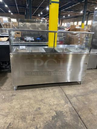 Commercial stainless steel 5-bay hot food table with sneeze guard, rear tray-slide, enclosed double shelf base, and hotel pans.