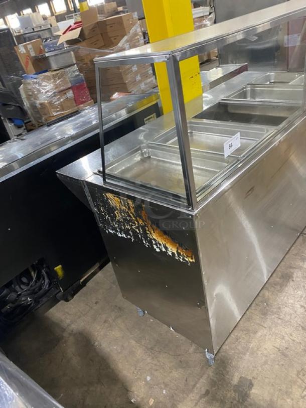 Commercial stainless steel 5-bay hot food/steam table with sneeze guard, tray-slide, and double shelf base. Natural gas powered.