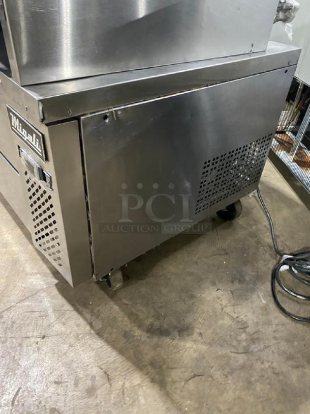 Migali stainless steel 2-drawer refrigerated chef base on casters, featuring a durable design and brand logo.
