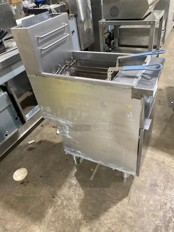Globe stainless steel natural gas deep fat fryer with backsplash, basket hanger, and fry baskets. On legs, shows wear.
