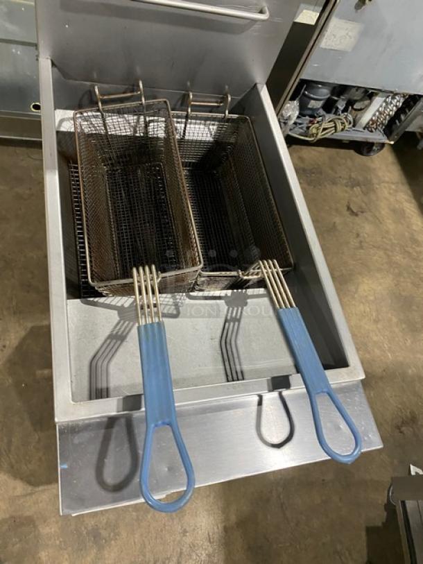 Globe stainless steel natural gas fryer with backsplash, basket hanger, and dual fry baskets. Features sturdy legs. Used condition.