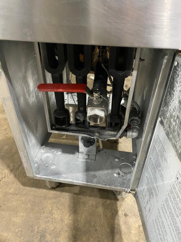 Globe commercial stainless steel natural gas fryer with backsplash, basket hanger, and fry baskets, on sturdy legs.