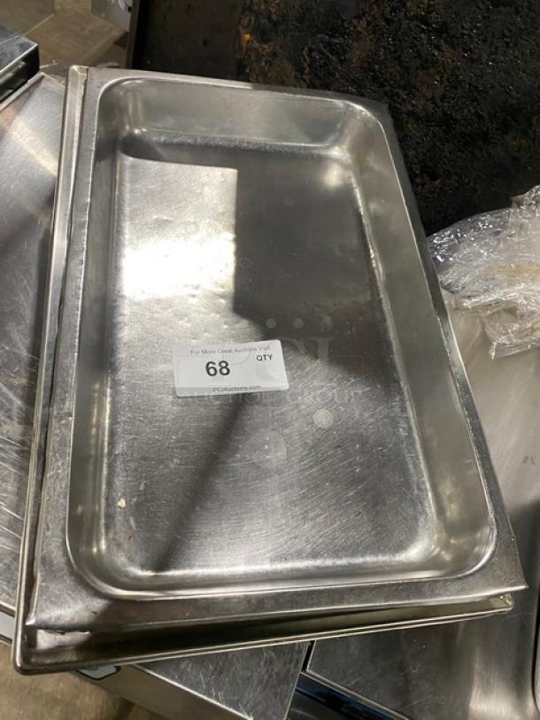 Lot of commercial stainless steel hotel/steamtable pans. Visible wear, stackable design. Label reads "68 QTY."