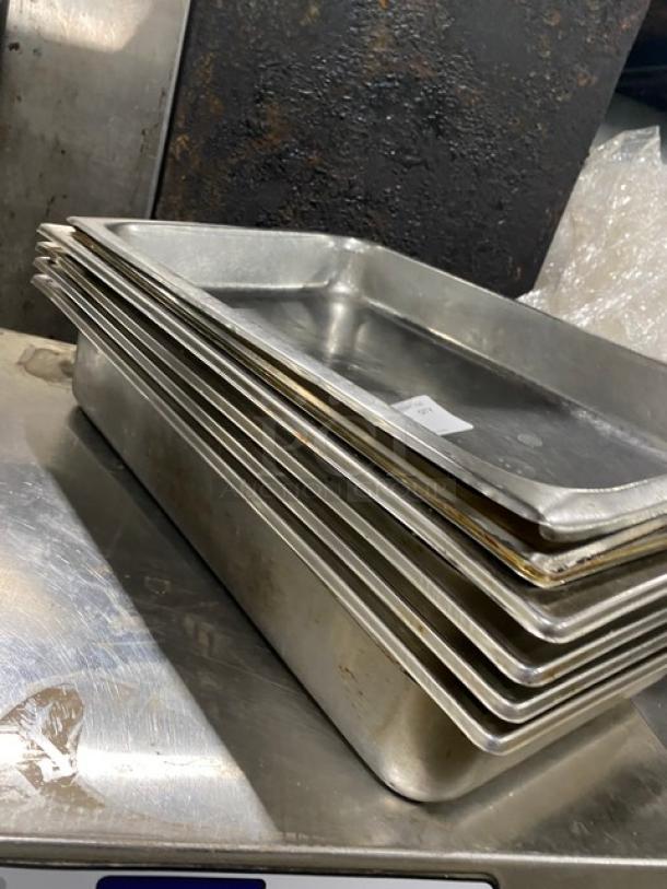 Stack of stainless steel hotel/steamtable pans in good condition. Features include durable material, uniform size, and a small price tag visible.