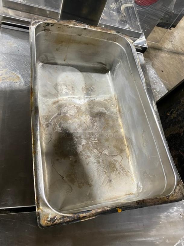Lot of commercial stainless steel hotel steamtable pans in used condition, showing signs of wear and tarnish.