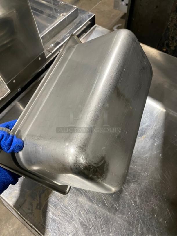 Lot of commercial stainless steel hotel/steam table pans in used condition, showing surface wear, suitable for restaurant use.