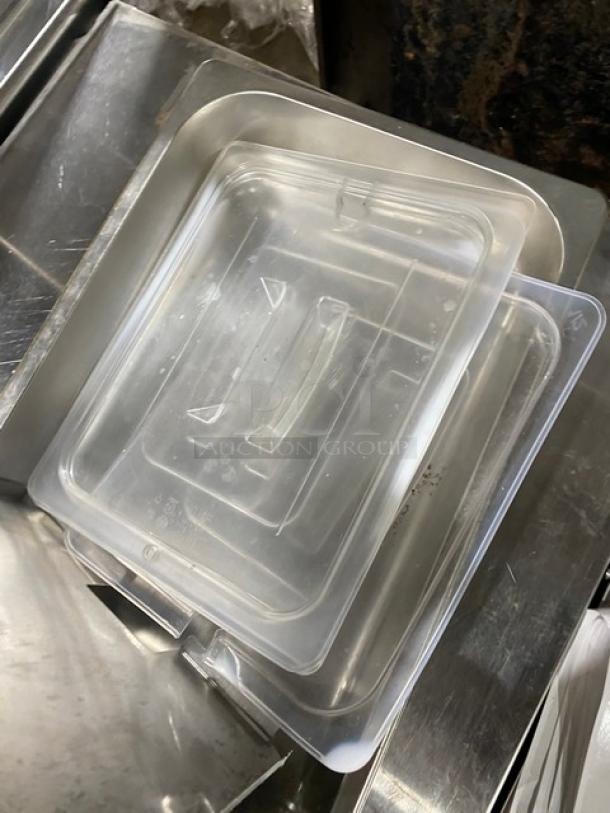 Lot of commercial stainless steel and clear polycarbonate pan lids, shown stacked. Ideal for steam table use.