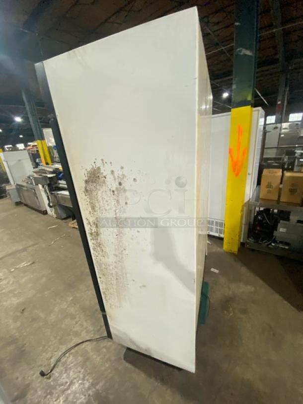 True GDM-49 commercial refrigerator, side view, shows wear and stains. Features poly coated wire racks, 115V, 1-phase.