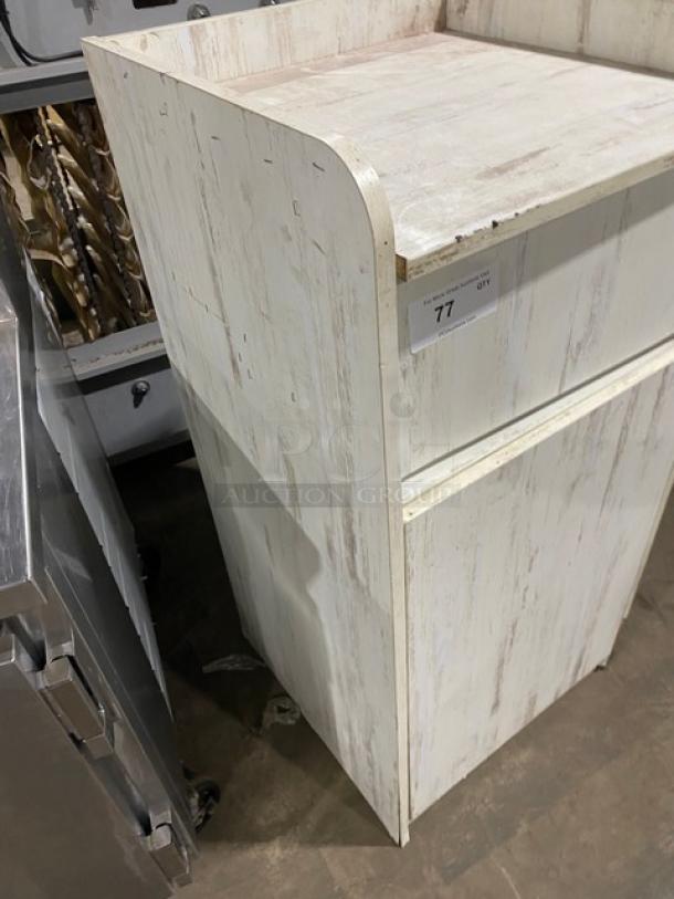 Commercial wooden trash cabinet in distressed white finish. Enclosed style with a worn surface, ideal for discreet waste storage.