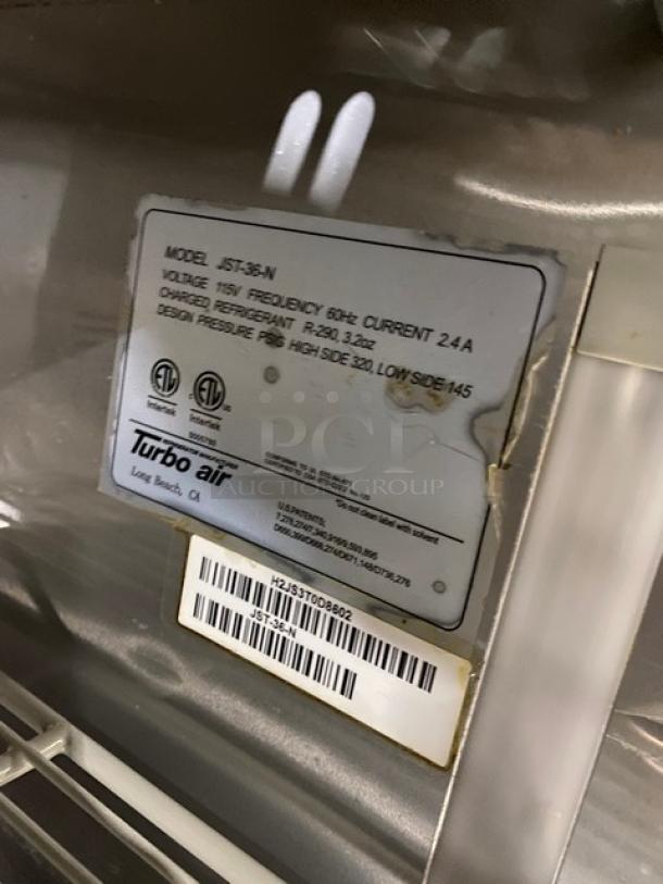 Turbo-Air JST-36-N commercial stainless steel single door refrigerated prep table. Features poly-coated wire rack, 115V. Model and serial number visible.