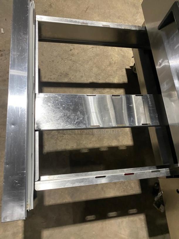 Commercial stainless steel 2-drawer refrigerated chef base, 115V, on casters, showing open drawer frame.