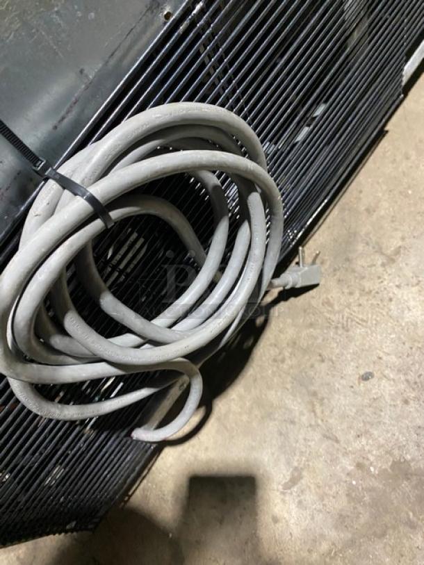 Turbo-Air commercial refrigerator, stainless steel, single door, poly-coated wire rack, on casters, shows power cord.