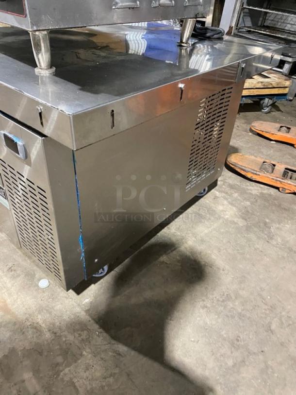 Duker's stainless steel 2-drawer refrigerated chef base with oversized worktop, SN: DUK22100423040000, on casters.