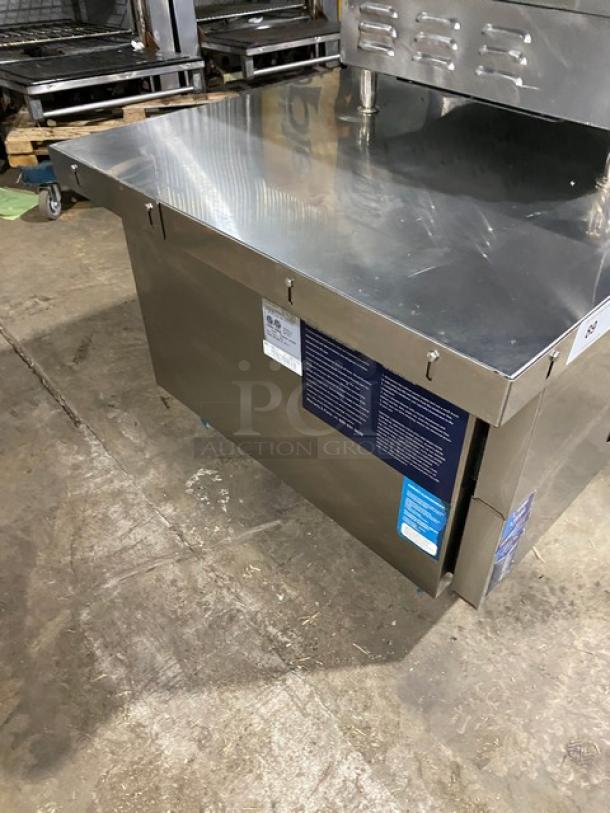 Duker's stainless steel 2-drawer refrigerated chef base with oversized worktop, SN: DUK22100423040000, on casters.