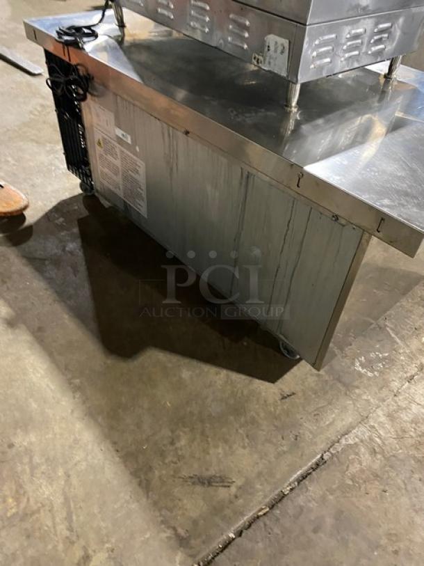 Duker's stainless steel 2-drawer refrigerated chef base with oversized worktop, SN: DUK22100423040000, on casters.