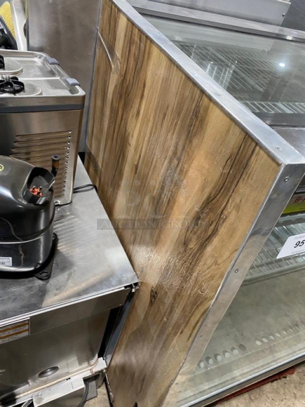 Commercial wooden style refrigerated meat deli display with straight glass, poly coated wire racks, and rear double sliding doors.