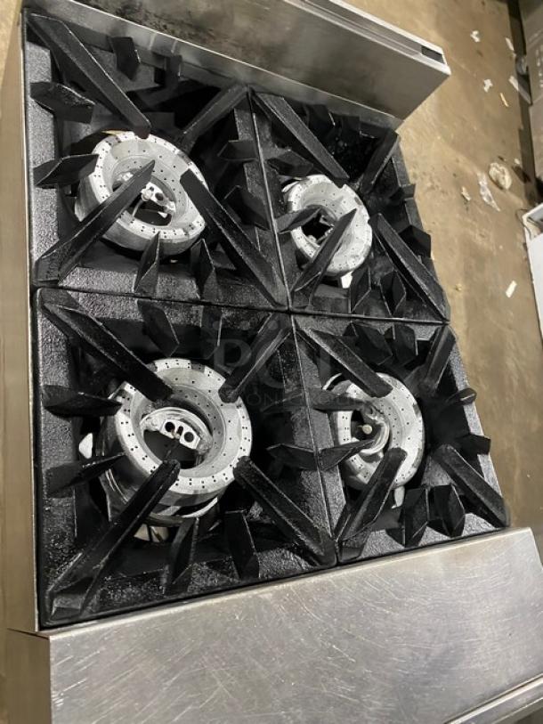 Vulcan commercial stainless steel 4-burner range with backsplash and enclosed cabinet base, natural gas-powered, on legs.