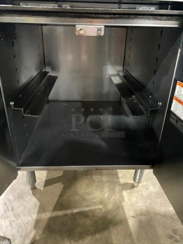 Vulcan commercial stainless steel 4-burner range with backsplash, enclosed cabinet style base, on legs. Natural gas powered.