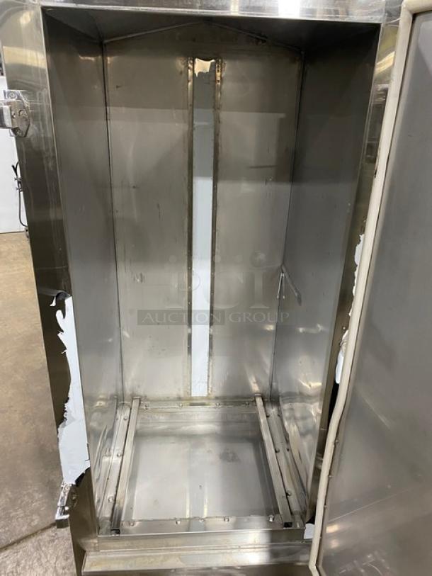 Commercial stainless steel natural gas smoker oven, free-standing on legs. Full-size interior, visible wear. Ideal for professional use.