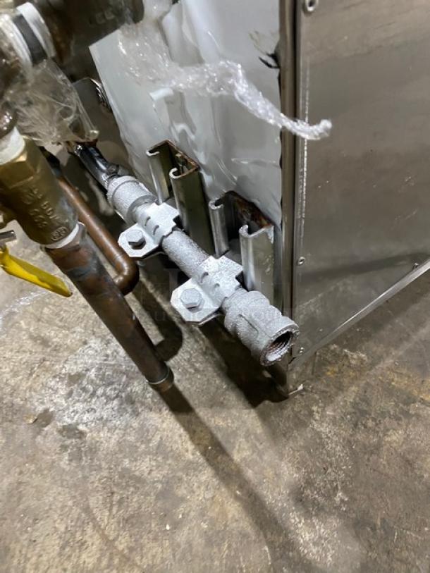 Commercial stainless steel natural gas smokehouse oven, full-size, freestanding on legs. Pipes and connections visible.