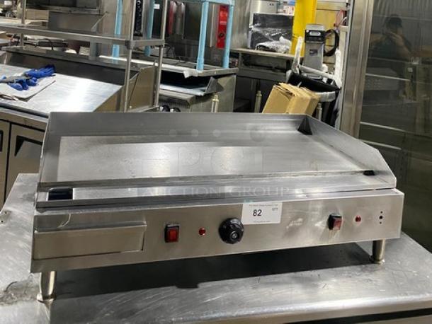 Commercial stainless steel electric countertop flat griddle with back and side splash, on legs, in used condition.