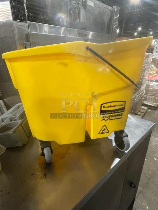 Rubbermaid WaveBrake Series yellow 35 Qt. mobile mop bucket with casters, shown in new condition on a metal surface.