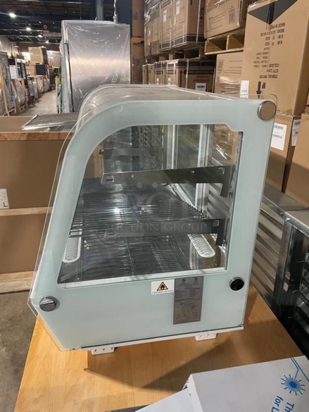 Brand new Marchia MDC161 white 36" curved glass refrigerated bakery display case. Features chrome racks, LED lighting, and rear sliding door. Serial: 1113910220138.