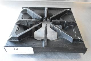 Brand new scratch and dent 12" x 12" cast iron spider grate with built-in bowl, minor imperfections, auction tag visible.