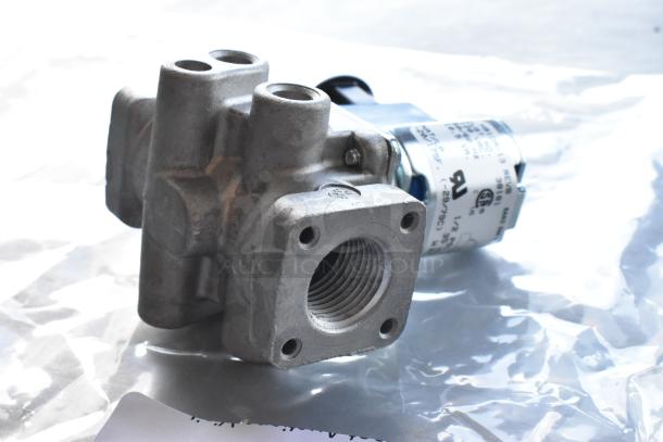 Metal valve component with threaded openings, featuring H91DA-13 markings, in new condition on clear packaging bag.