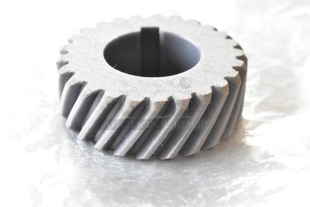 New industrial gear, metallic, helical teeth. Part of a 3-item scratch and dent auction. Includes H91DA-13 Unit, Manitowoc FSG Cord.