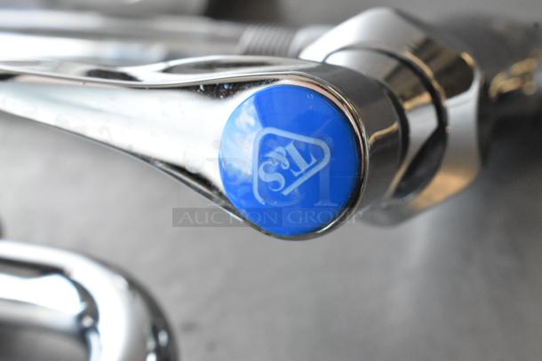 Brand new T&S faucet with handles and spray nozzle, scratch and dent condition, chrome finish, blue T&S logo visible.