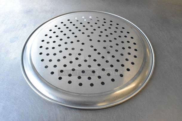 Brand new metal round perforated baking sheet, slight scratches and dents visible, ideal for ventilation in baking.
