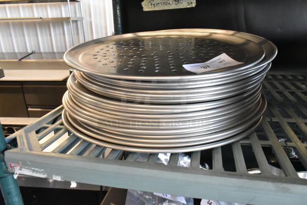 21 new scratch and dent metal round perforated baking sheets, stacked. Auction label visible.