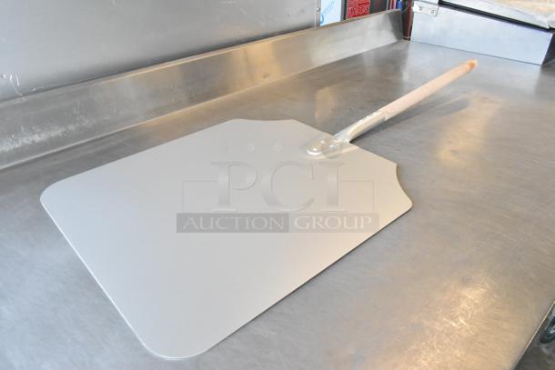 Brand new metal pizza peel with minor scratches, featuring a sturdy wooden handle. Two units included in the auction.