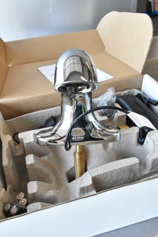 Brand new Zurn ZG6955 faucet in packaging, scratch and dent condition, chrome finish, visible Zurn logo, parts included.