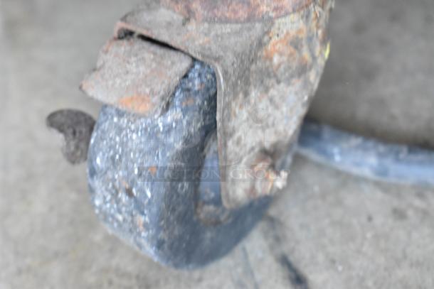A rusted commercial caster wheel from an Electro Freeze 30TN-CAB-113 ice cream machine shows signs of wear and age.