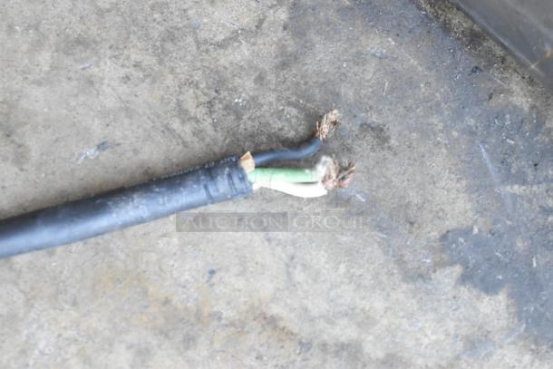 Frayed power cable on concrete, part of a Taylor C709-27 ice cream machine, indicating potential repair needed.