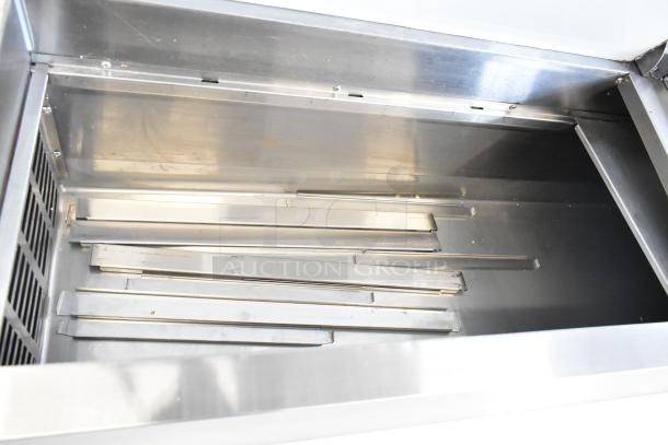 Avantco 178SSPPT2 commercial pizza prep table interior with stainless steel finish, showing shelving components.