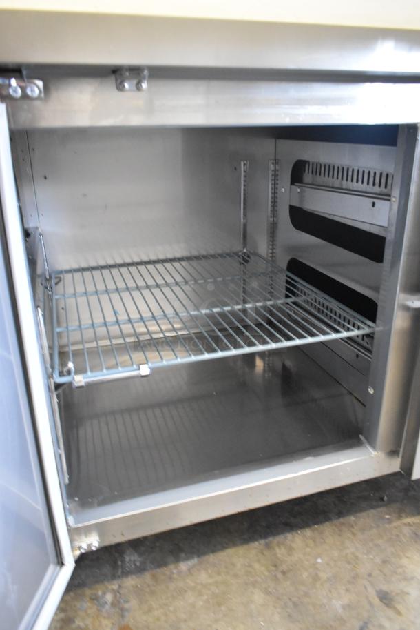 2024 Avantco 178SSPPT2 stainless steel pizza prep table interior, featuring wire shelving. Clean and spacious condition.