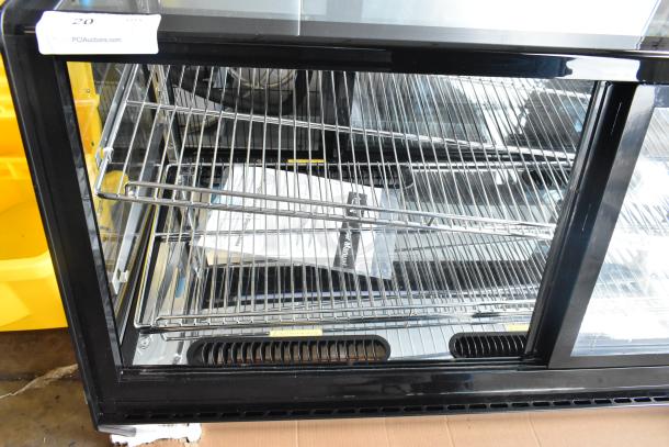 Brand new Avantco 360BCSS48HCB 48" black bakery display case with LED lighting, self-serve style, some scratches and dents.