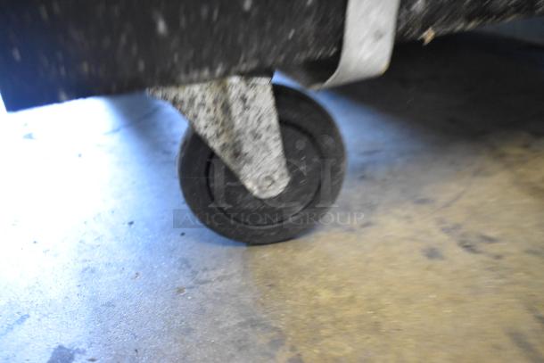 Beverage Air BM23-B kegerator commercial caster. Metal wheel, slightly worn, on smooth floor surface.