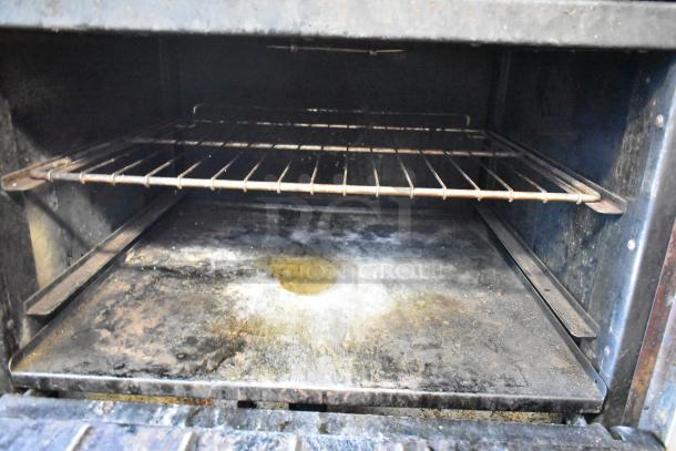 Imperial Stainless Steel Commercial Gas Range with 6 Burners, oven, overshelf, backsplash, and casters. Well-used condition.