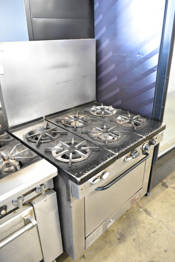 Southbend stainless steel 6-burner gas range with oven and backsplash. Commercial-grade, wear visible, sturdy condition.