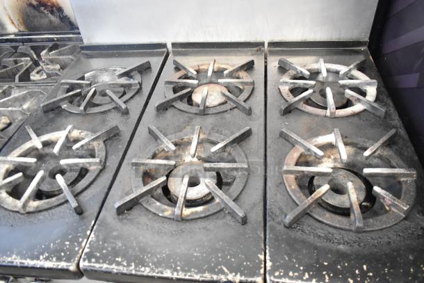Southbend commercial stainless steel gas range with 6 burners, oven, and backsplash. Used condition, signs of wear visible.
