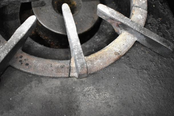 Close-up of a burner from a Southbend commercial stainless steel gas range, showing signs of use and wear.