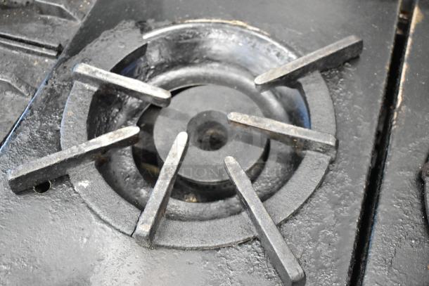 Southbend stainless steel commercial range close-up of gas burner, showing cast iron grates, used condition.