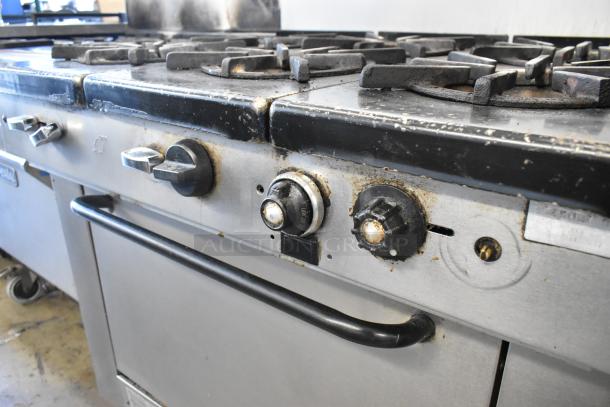 Southbend stainless steel commercial 6 burner gas range with oven and backsplash. Some wear visible on knobs and surfaces.