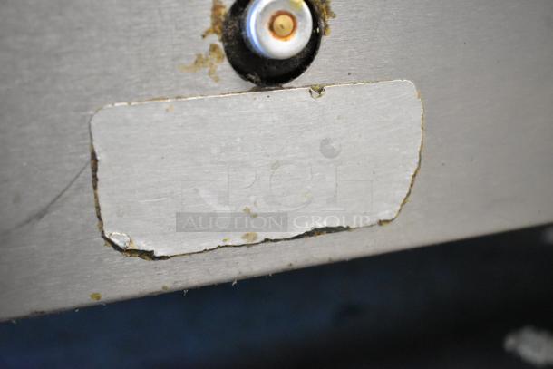 Close-up of a worn label on a Southbend stainless steel commercial gas range. Slight discoloration is visible.