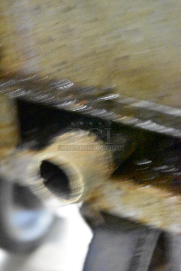 Blurry close-up image of metal component on Royal RPT-50 fryer. Stainless steel, commercial use, natural gas powered.