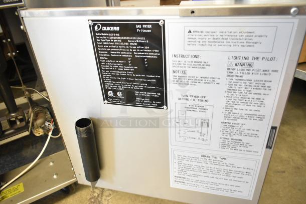 Dukers DCF5-NG stainless steel commercial gas fryer, 150,000 BTU, with 2 metal fry baskets and casters. Instruction panel shown.